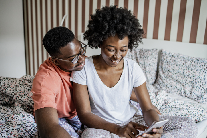 Young couple scrolling through the social media together in the morning