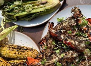 A spread of grilled jerk lobster tails, grilled corn and grilled Romaine salad dressed in a Meyer lemon vinaigrette.