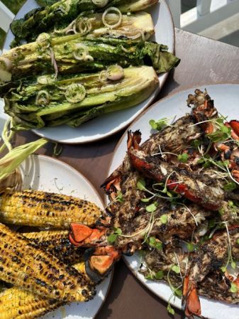 A spread of grilled jerk lobster tails, grilled corn and grilled Romaine salad dressed in a Meyer lemon vinaigrette.