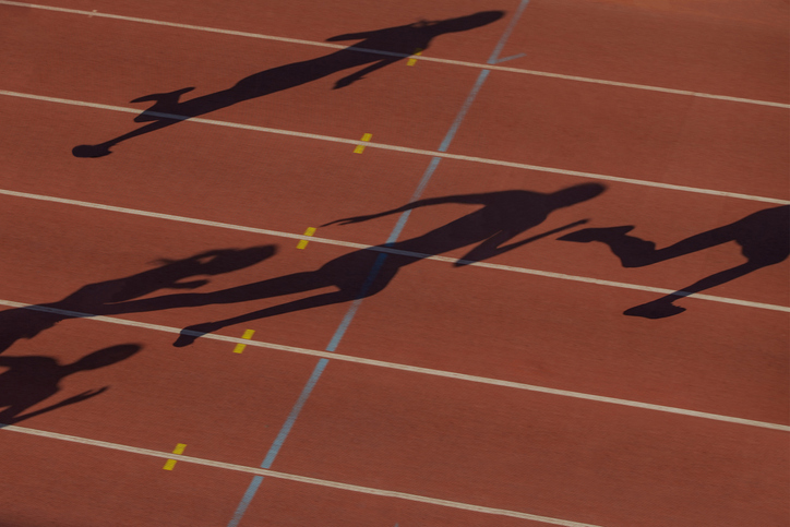black silhouette group female runners on red track stadium running sprint race