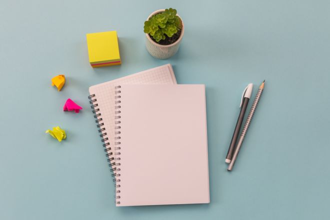 Notebooks, pen, stationery on a blue background. Conceptual image. Workspace.