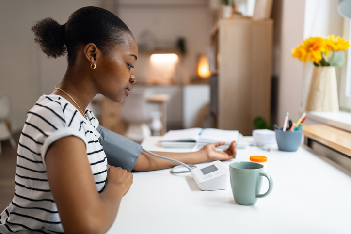 Young woman measuring blood pressure at home - Joel Bervell, hypertension, Instagram, Black people,