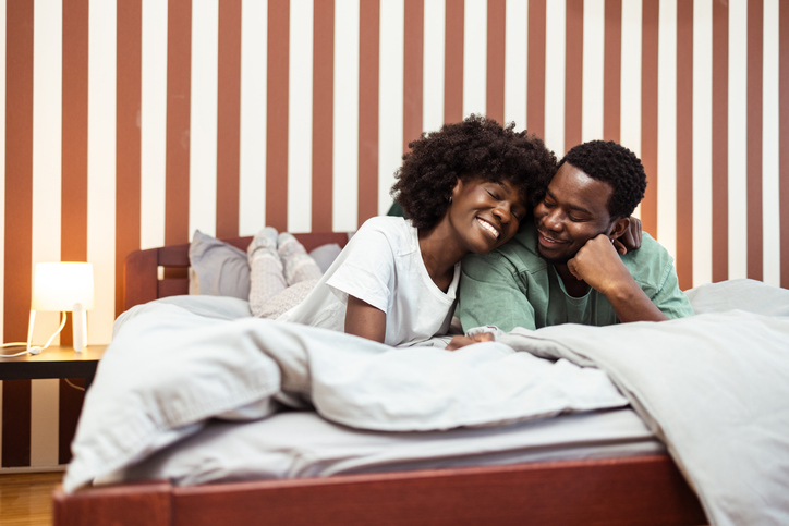 Young African American couple lying in bed in the morning