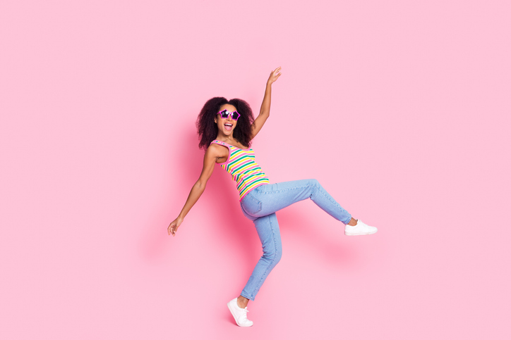 Full size photo of overjoyed lovely woman dressed knit tank in glasses walk on tiptoe dancing have fun isolated on pink color background