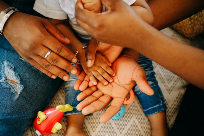 small hands palms of a black baby and his parents close-up