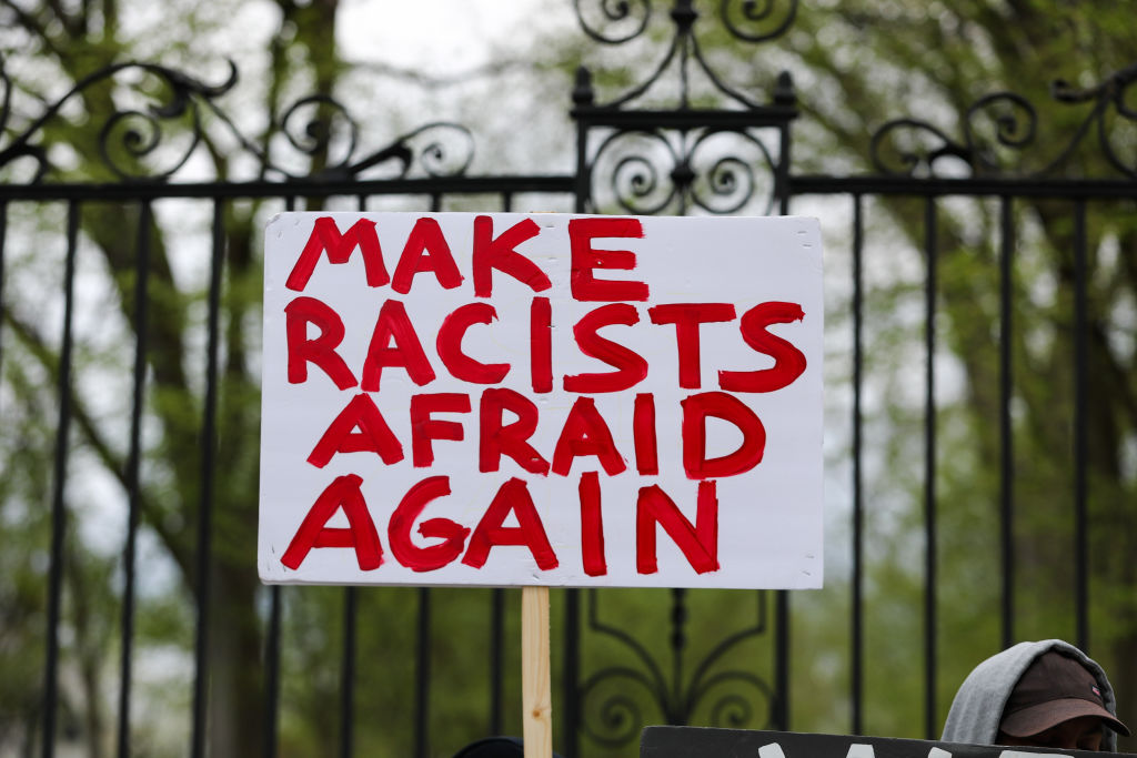 A protester holds up a placard saying