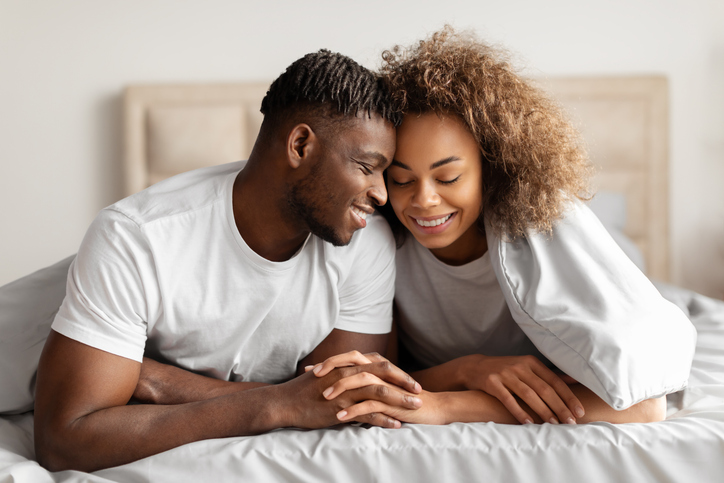 Happy Black Lovers Couple In Bed Holding Hands Touching Foreheads