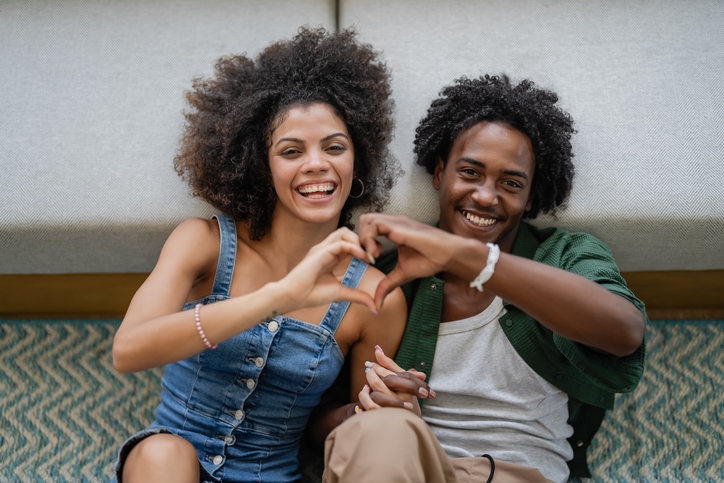 A young cheerful couple of African descent in a modern living room having an intimate moment of love and affection
