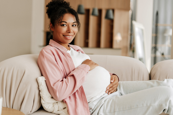 Beautiful pregnant woman relaxing on sofa at home