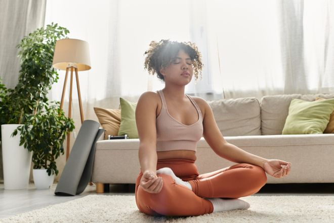 A young woman meditates peacefully at home on a serene afternoon, embracing tranquility and calmness