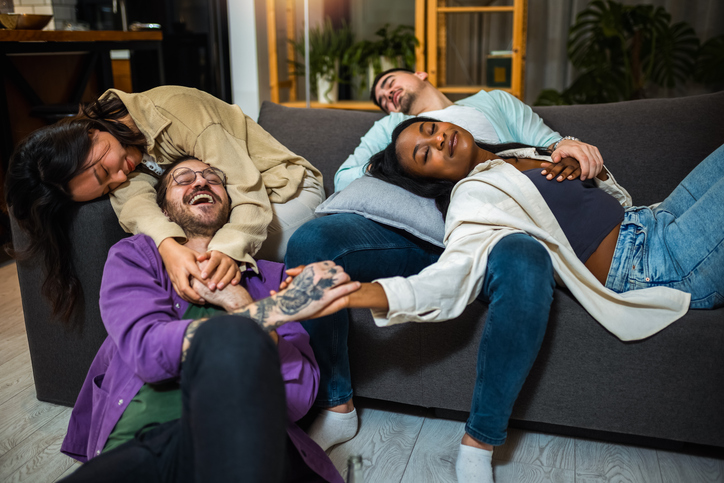 Party multiracial friends, drunk and hungover sleeping on a sofa in the living room after the party.