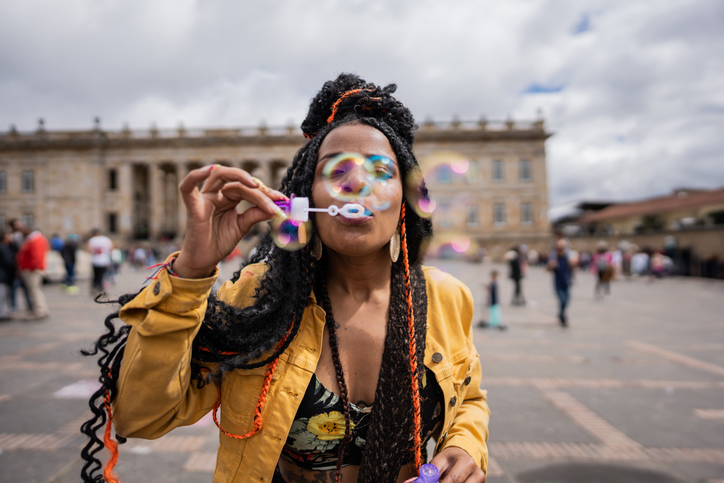 Mid adult woman playing soap bubbles in historic district of Bogota, Colombia