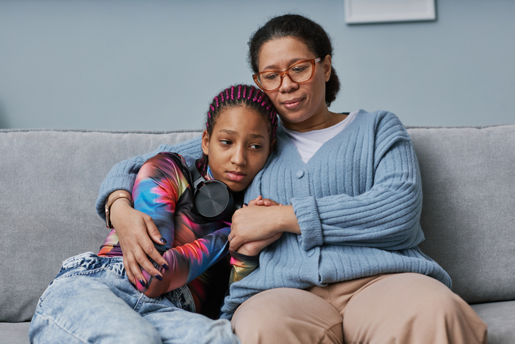 Black woman embracing teenage daughter