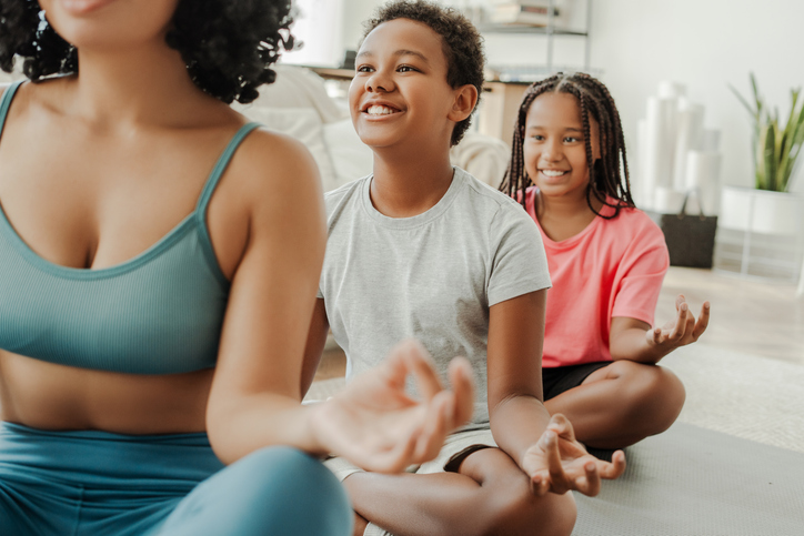 Family practicing yoga and meditation together at home
