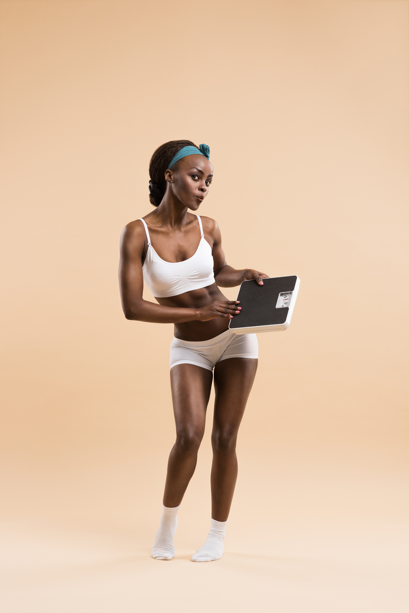 Sexy fit african woman posing with scales