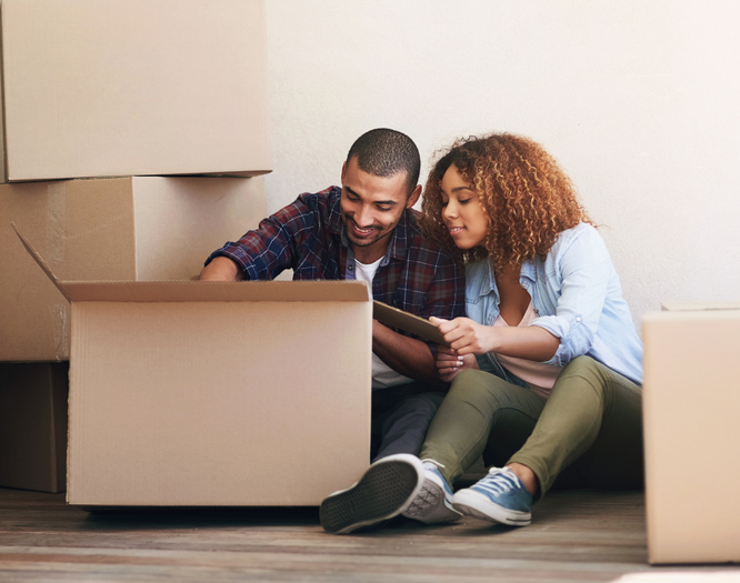 New home, boxes and couple on floor, real estate and property with package, moving in and search for items. Apartment, man and woman on ground, cardboard and relocation with achievement and happiness