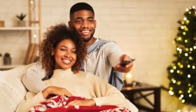 Afro couple in love at Christmas eve enjoy watching tv