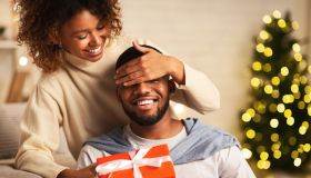 Xmas surprise. Loving wife giving gift to husband