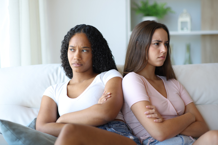Angry lesbian couple or friends ignoring each other at home