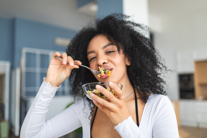 Young adult woman enjoying her pasta salad