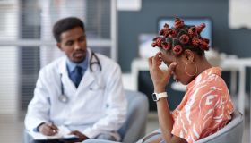 Frustrated Black Woman Rubbing Eyes After Getting Bad News at Doctors Office