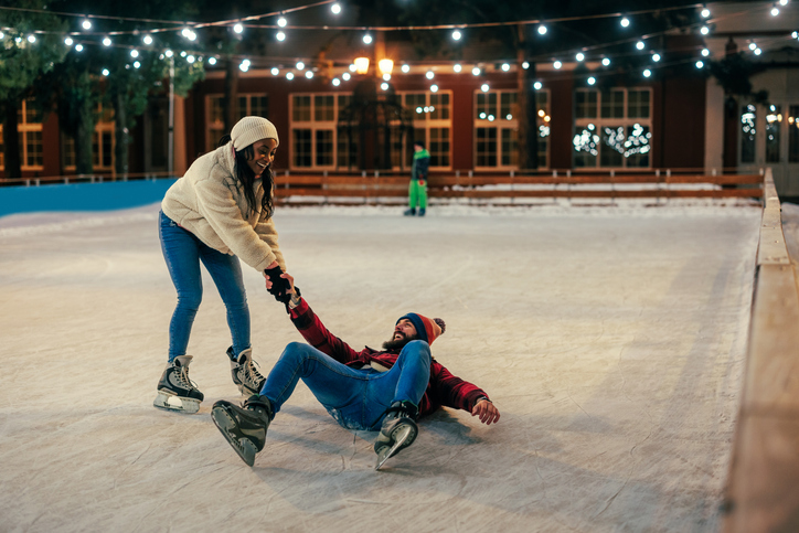 Woman trying to pick up her boyfriend on ice rink