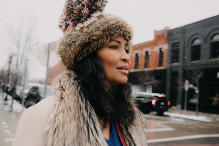 Woman stands on a snowy city street