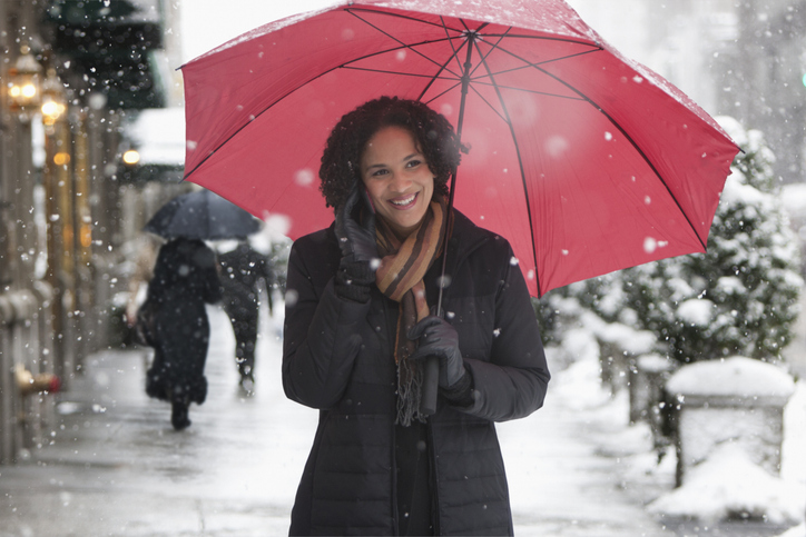 Young woman smiling talking on the phone in the snow