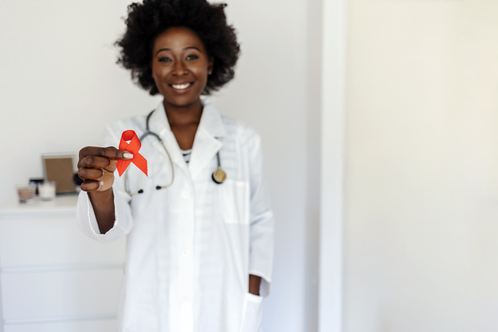 Doctor Hands Holding Red Cancer Awareness Ribbon.