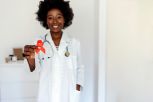 Doctor Hands Holding Red Cancer Awareness Ribbon.