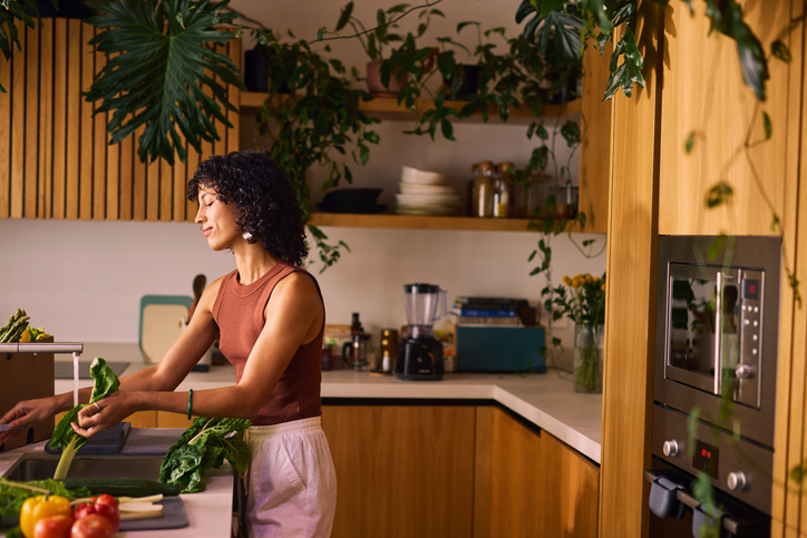 Focused on Wellness, Woman Cleans Fresh Greens to Enhance Metabolism and Nutrition in Her Diet