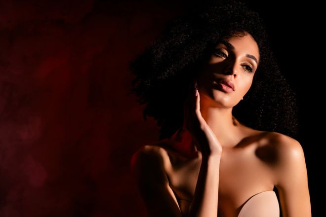 Photo of seductive lady nude shoulders enjoying herself empty space isolated concrete red color wall
