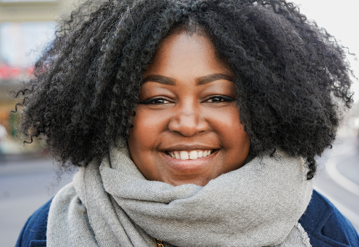 Happy young african woman smiling on camera outdoor during winter time