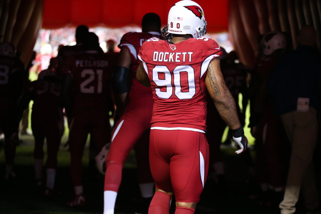 NFL player Darnell Dockett (90) stands with teammates in the tunnel before an NFL game between the Indianapolis Colts and Arizona Cardinals in Glendale, Arizona November 24, 2013. (Photo by Tom Hauck/Getty Images) color image,photography,horizontal,usa,sport,anticipation,sports team,standing,american football - sport,nfl,match - sport,tunnel,arizona cardinals,indianapolis colts,defensive end,nfc west,darnell dockett