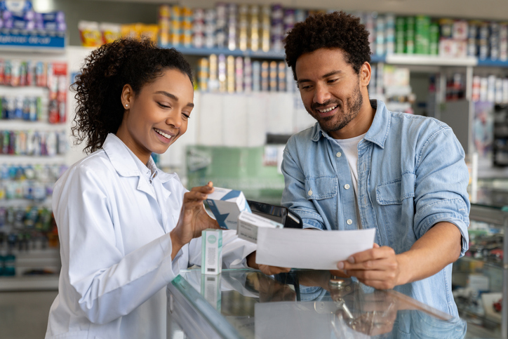Pharmacist selling prescription medicine at a drugstore