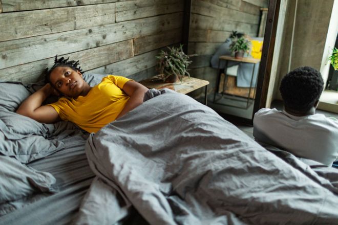Young adult couple with relationship difficulties in bedroom