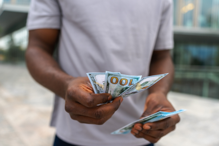 Man hands holding money dollar bills on urban street outdoor. Businessman hands counting currency money outdoors near office bank building. Unrecognizable man holding cash. Finance economy banking.