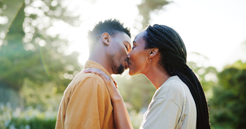 Kiss, love and black couple in nature in morning together for bonding, relationship and affection outdoors. Relax, dating and man and woman outdoors for romance, holiday and commitment on weekend