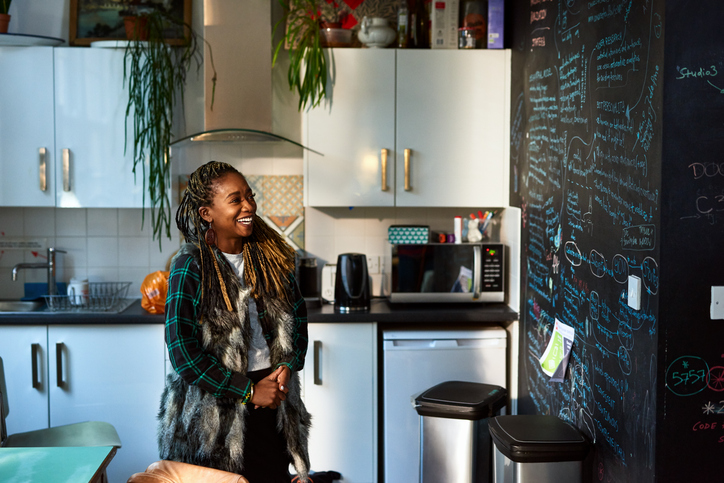 Cheerful woman looking at office blackboard