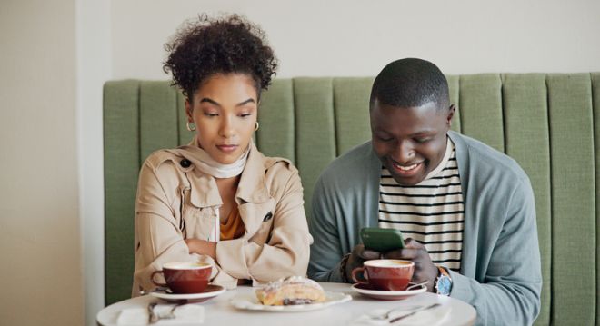 Cafe, man and ignore woman with phone for internet addiction, attention and annoyed with bad date. Interracial people, coffee shop and jealous partner for cheating, toxic relationship or overthinking