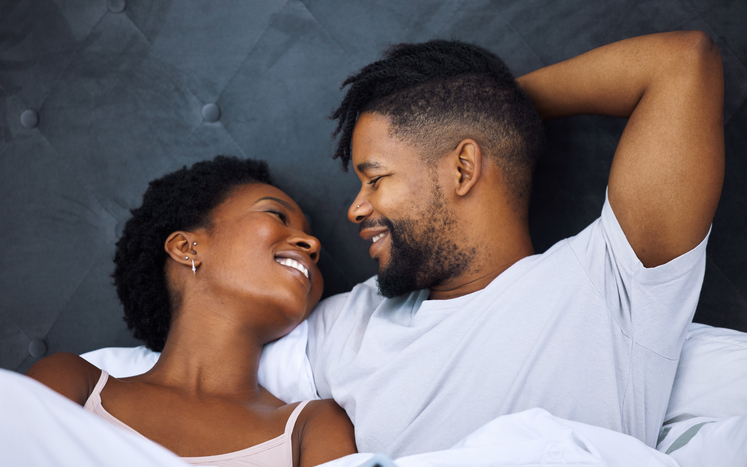 Shot of a young couple being intimate in bed at home