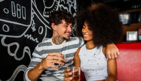 Young couple talking and drinking soda on restaurant