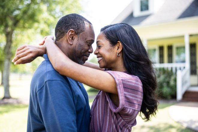 Portrait of married couple in front of rural farm home