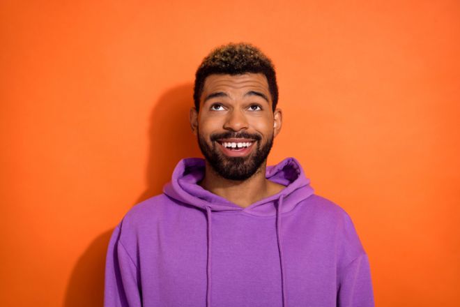 Photo of attractive happy man wear stylish outfit raise eyes up look empty space isolated on yellow color background