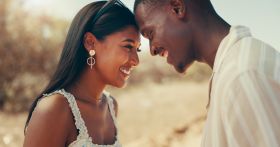 Forehead, happy and couple in countryside for holiday, vacation and travel on weekend. Road trip, nature and man and woman with smile for bonding, relax and relationship on adventure together