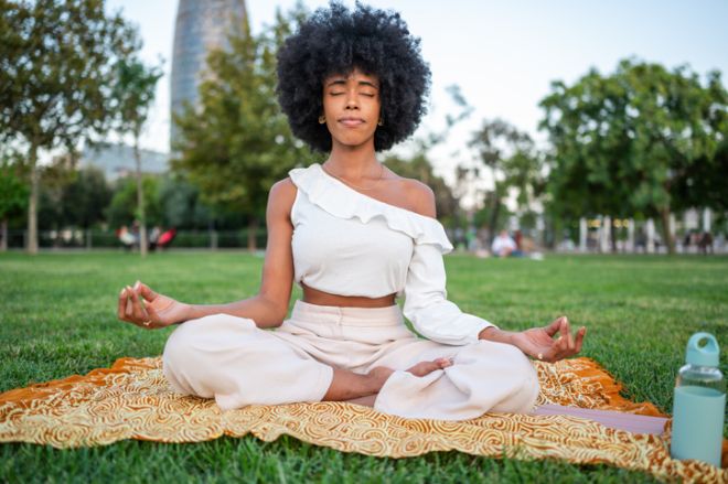 Young woman meditating in a park in Barcelona, Spain