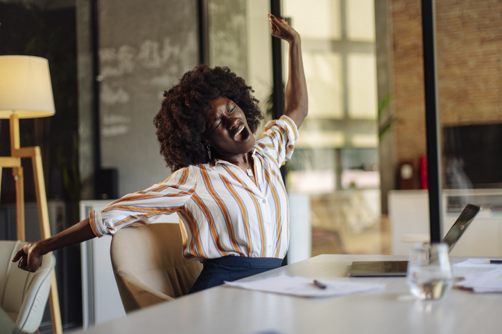 Young Professional Stretching While Working in a Modern Office Setting