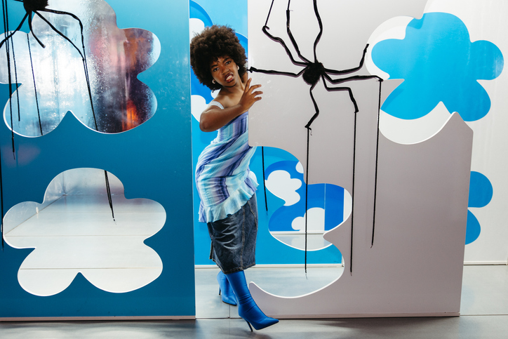 Scared Woman Reacting to Halloween Spider Decor