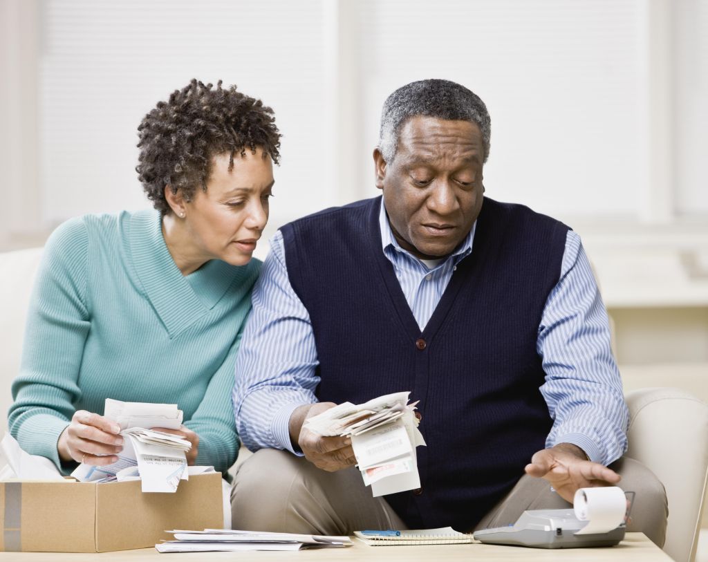 African couple adding up receipts