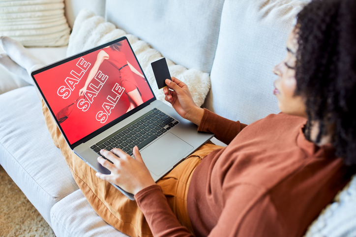 Woman Relaxing on Sofa Shopping Online with Laptop and Credit Card